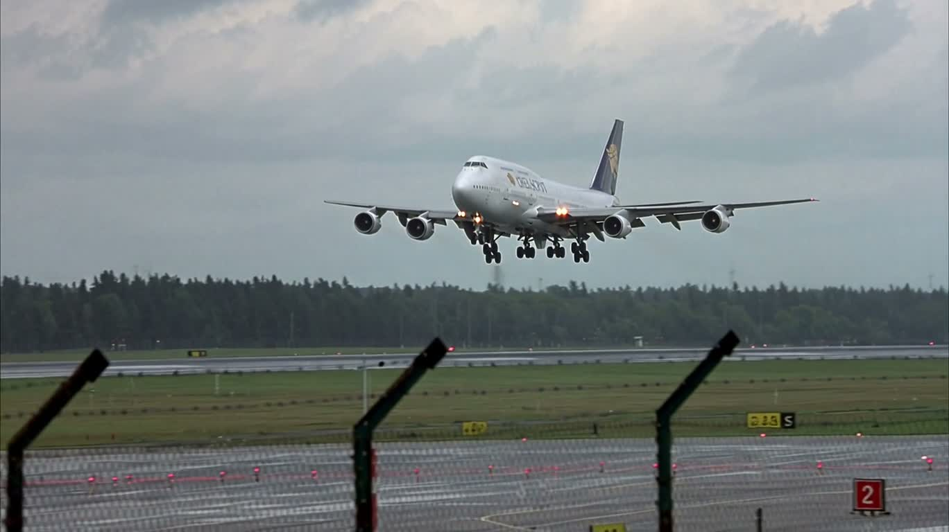 Боковой снимок посадки Boeing 747 под проливным дождём