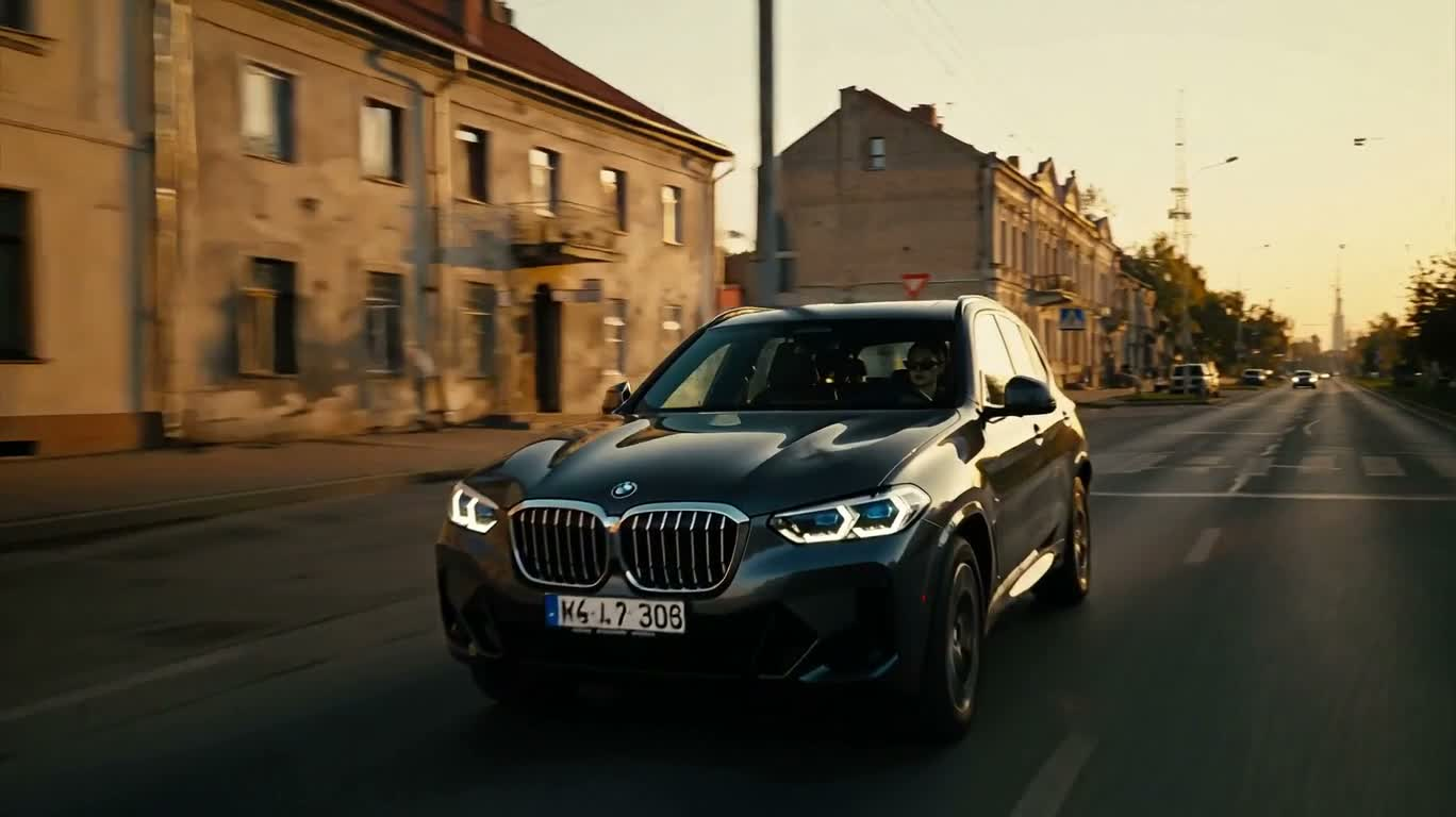 Tracking shot of a BMW on the streets of Łódź at golden sunset