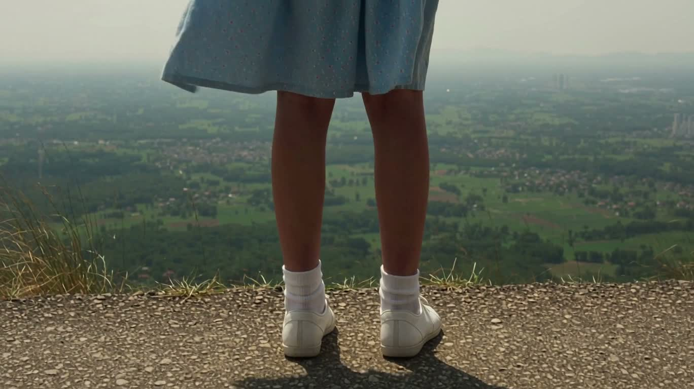 風の中で遠くを見つめる少女
