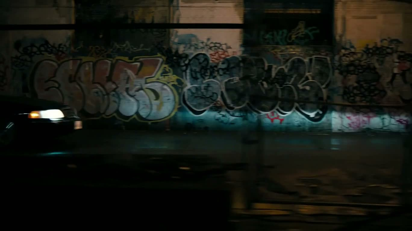 雨夜のグラフィティ路地を駆ける黒いセダンの追跡