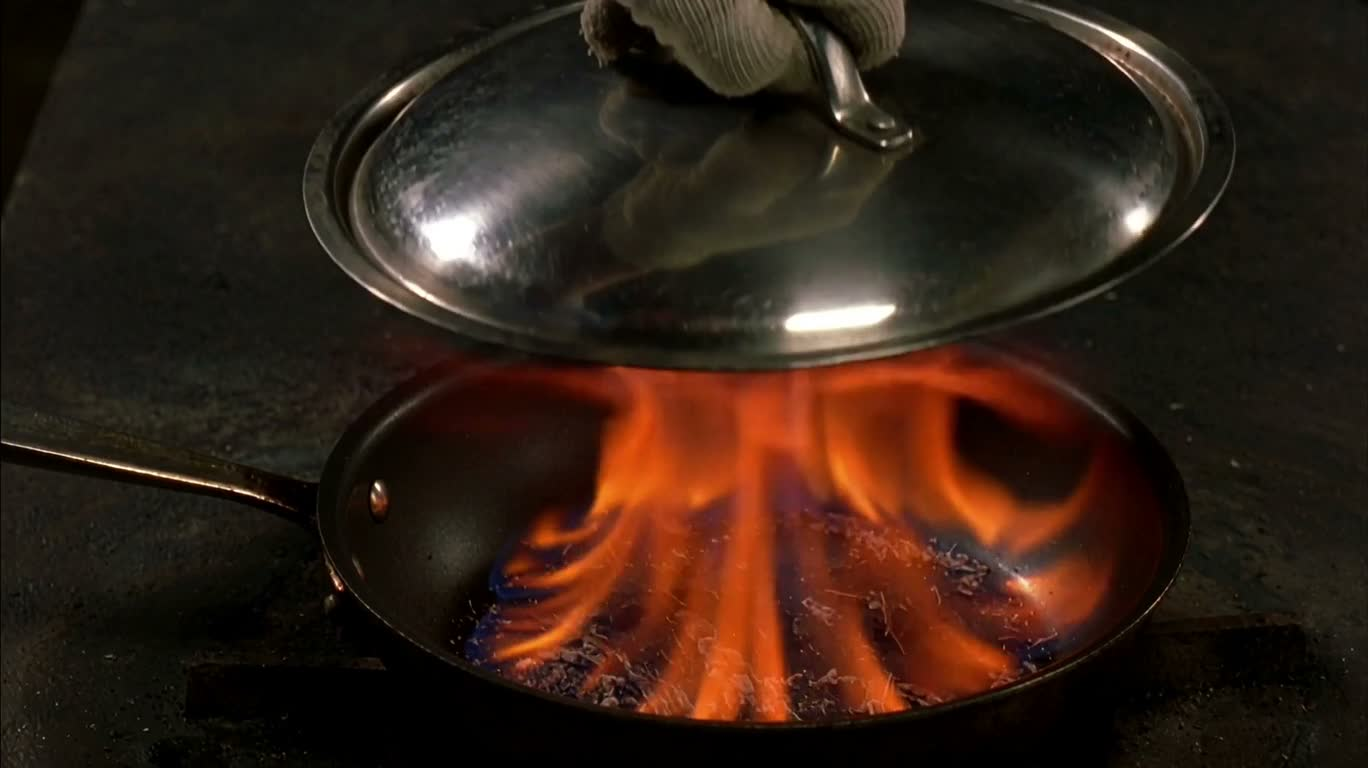 Metal lid smothering flames