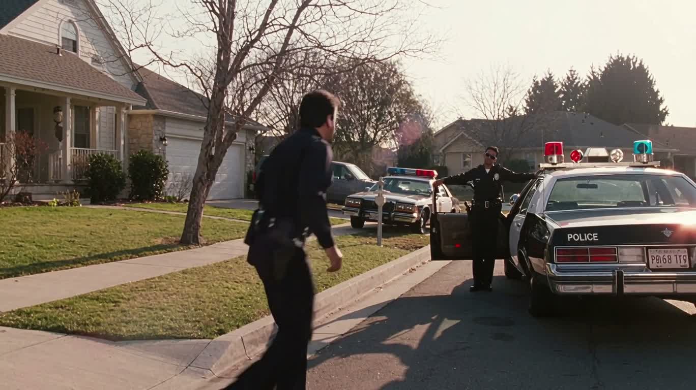 Le duo loufoque près de la voiture de police
